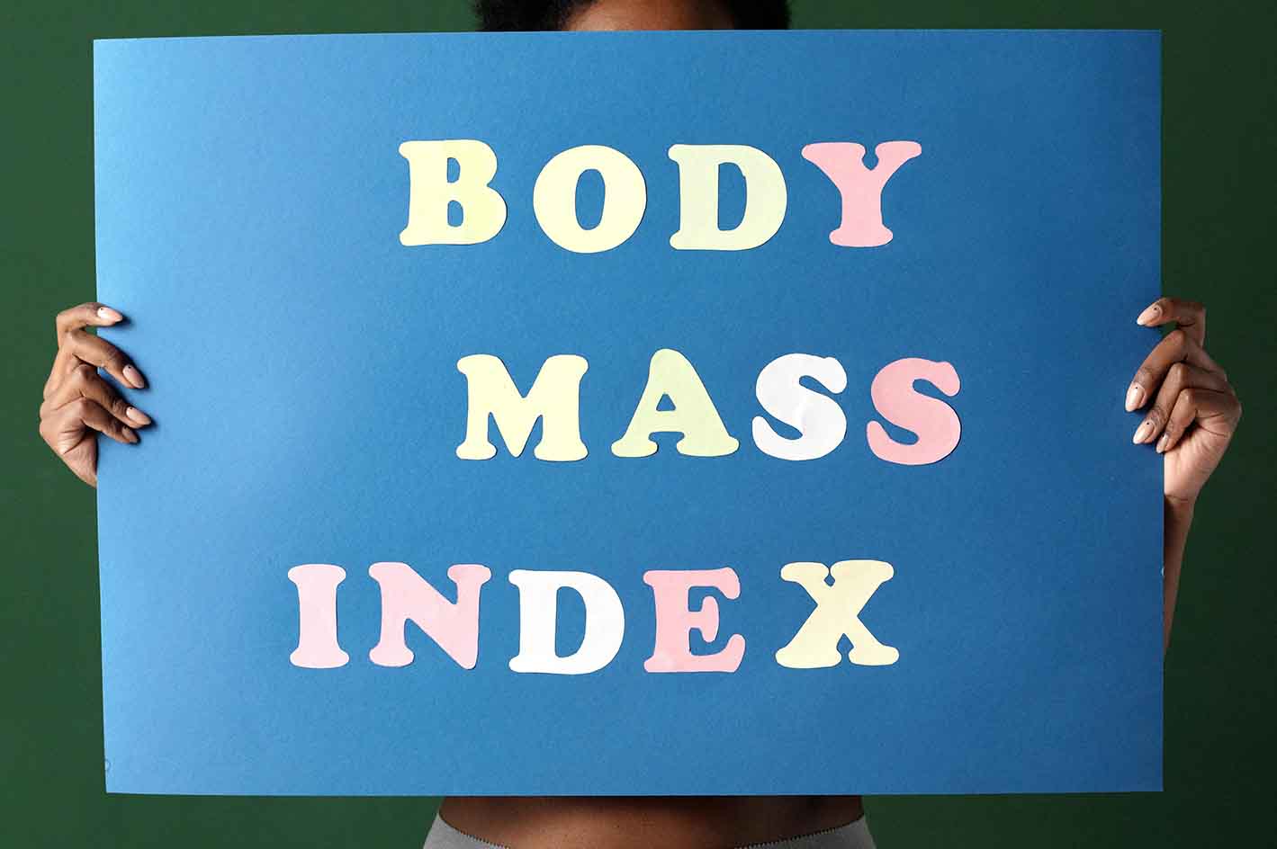 Eine Frau hält ein Schild mit der Aufschrift Body Mass Index.