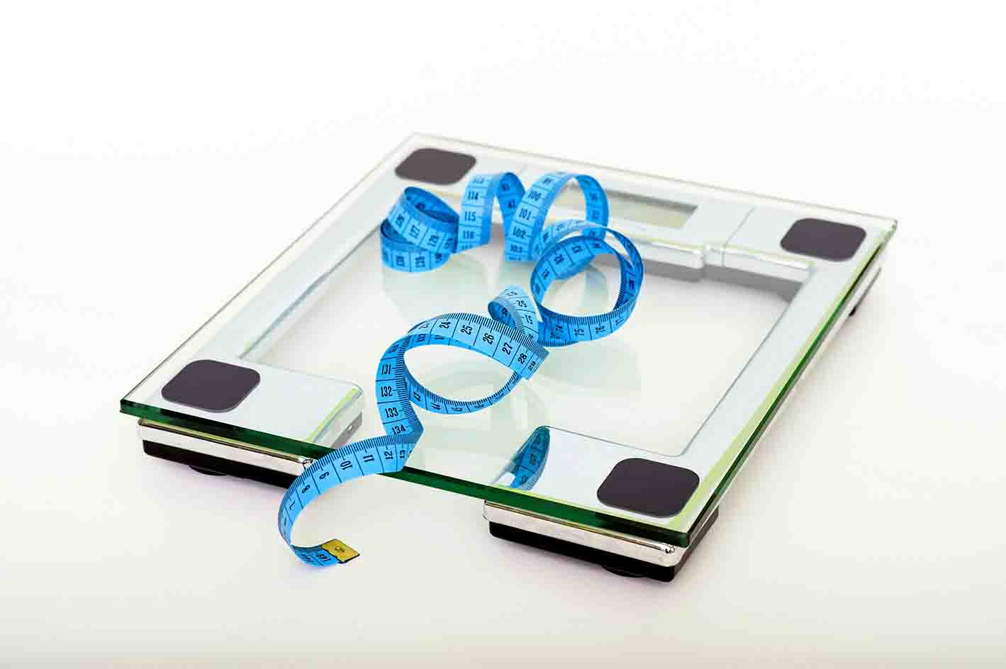 Eine Waage mit Maßband, die zeigt, wie der BMI gemessen werden kann